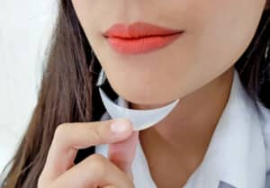 Woman testing silicone chin implant before augmentation surgery, concept of facial implants and cosmetic consultation at clinic